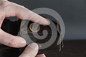 Nearly empty wallet with one euro coin