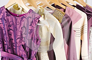 Neat female dresses with ornament hanging on a shelf