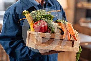 Neat nice courier holding a box full of healthy foods