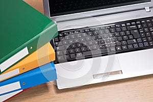 Neat office desk with laptop and stacked folders