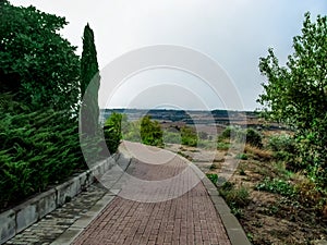 A neat red and gray paved footpath from above on a hill outside the village of Montfalco Murallat Lleida, Spain. Well-maintained photo