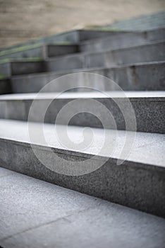 Neat and tidy grey stair steps made of stone and granite tiles with a curb.