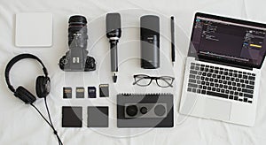 A neatly arranged collection of technology items on a white surface. Includes a digital