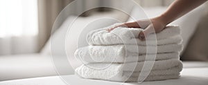 The neatly arranged stack of soft white towels on a bed..AI generated image