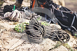 A neatly folded climbing rope lies on a rock