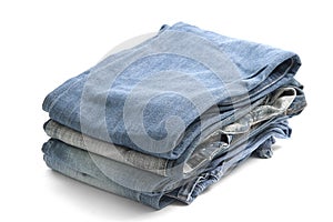 Neatly folded stack of denim jeans showing texture and different shades of blue