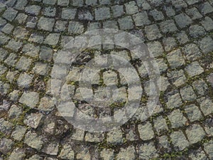 Neatly laid out old paving stones. Pavement on the square of the old town. Square and rectangular stones on the ground, covered