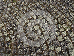 Neatly laid out old paving stones. Pavement on the square of the old town. Square and rectangular stones on the ground, covered