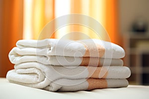 Neatly stacked white towels on bed in bedroom with spacious view, ample room for text