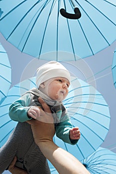 Neborn baby under a blue umbrellas.