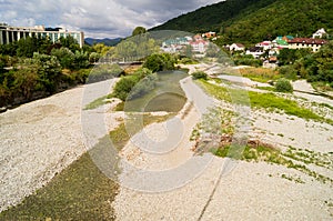 Nebug River. Mountains of the Caucasus. Forest plantations in the mountains. The river goes into the mountains. Houses