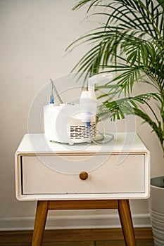 Nebulizer on a nightstand near a palm tree