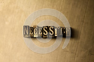 NECESSITY - close-up of grungy vintage typeset word on metal backdrop