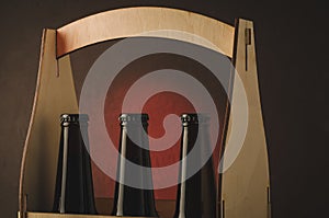 neck of beer bottles in a wooden box/neck of beer bottles in a wooden box on a red tslet background