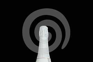 Neck of a bottle of champagne in white foil on a black background