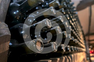 The neck of a bottle of wine in a wine cellar