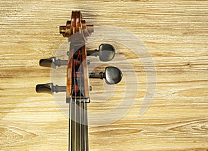 Neck and headstock of a cello on the left side of the image.
