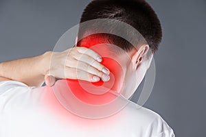 Neck pain, man suffering from backache on gray background