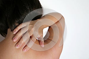 Neck pain, woman clutched by hand her shoulder, back view