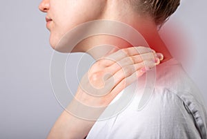 Neck pain. Woman hand holding painful neck with red point closeup. Muscle spasm, injury, trauma or inconvenient posture