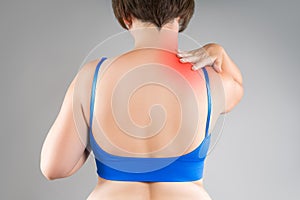 Neck pain, woman suffering from backache, gray background, health problems concept