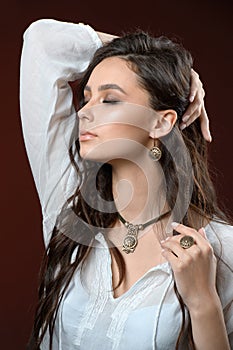 Necklace and earring on young woman. Beautiful model with perfect long hair