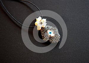 A necklace evil eye and pearls on a black surface