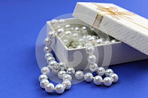 In a white box lies pearl beads