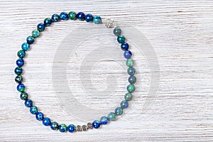 Necklace from polished azurite beads on gray