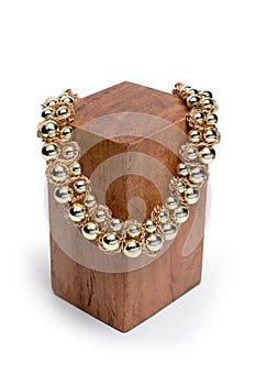 Necklace on wooden stand on white