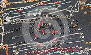 necklaces and bracelets and anklets some with red chili pepper in a jewelry stall in the shopping center