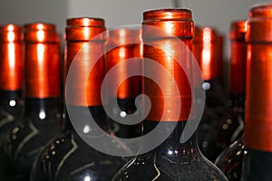 Necks of wine bottles with bright red foil closeup
