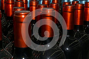 Necks of wine bottles with bright red foil closeup