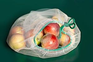 Nectarine in ecological packaging. Reusable bags for vegetables and fruits. Shopping in the store, retail. Eco-friendly packaging