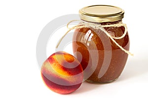 Nectarine jam in a glass jar and fresh peaches on white background