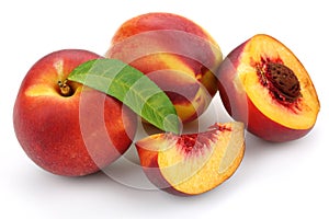 Nectarine peaches with slice and leaf isolated on white