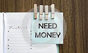 Need Money notes paper and a clothes pegs on wooden background