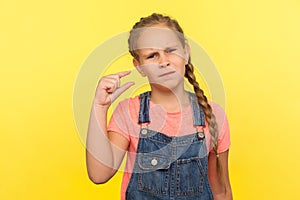 Need some more. Portrait of upset little girl doing a little bit gesture and looking with displeased imploring expression