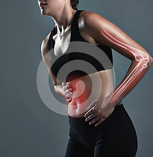 Need something to relief the pain. Studio shot of a sporty young woman experiencing stomachaches.