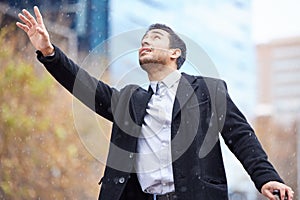 Need a taxi and fast. a handsome young man hailing a taxi in the rain during his morning commute into work.