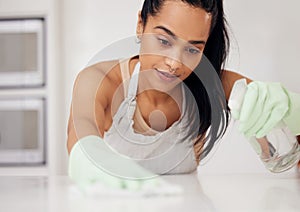 They need to be shiny. Shot of a young woman cleaning a counter at home.