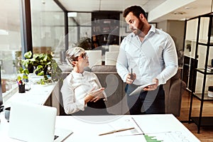 These need to get done before I go on leave. two businesspeople having a discussion in an office.