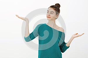 We need to make decisions. Portrait of cute good-looking woman with bun hairstyle in stylish loose sweater holding palms