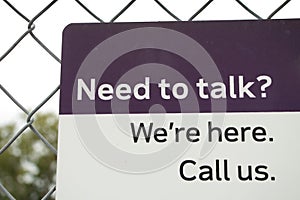 need to talk were here call us sign in white and black print on purple and white