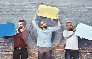 We needed to say something. a group of young men holding speech bubbles against a brick wall.