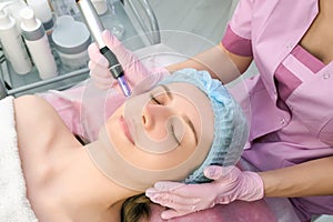 Needle mesotherapy. Cosmetologist performs needle mesotherapy on a womans face