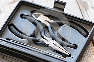 Needle nose pliers, wire cutter in plastic box