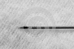 Needle of syringe on soft background is macro, black and white photo