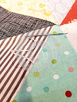 Needle and thread on colorful quilting triangles