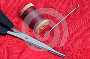 Needle and thread on a red background